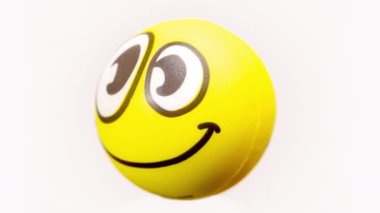 a soft ball with smiley emoji face turning