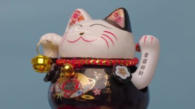 Lucky beckoning manejo neto cat waving, isolated against blue