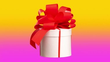 A gift box with red bow spinning against pink and orange background