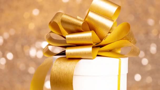 Gift Box Gold Bow Spinning Golden Sparkling Background — Stockvideo