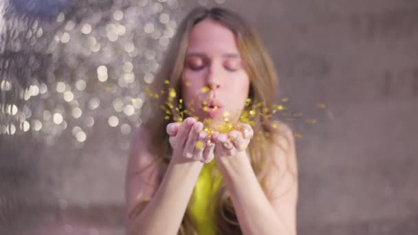 Pretty Woman Blows Sparkling Gold Confetti — Vídeo de stock