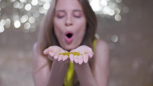 Pretty Woman Blows Sparkling Gold Confetti — Vídeo de stock