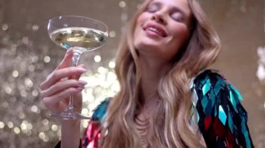 A stylish and pretty woman dancing holding a glass of champagne