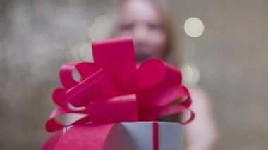 A beautiful woman with a gift box with red bow 