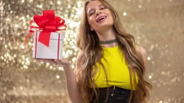 A beautiful woman holding a gift box with red bow 