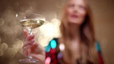 A stylish and pretty woman dancing holding a glass of champagne