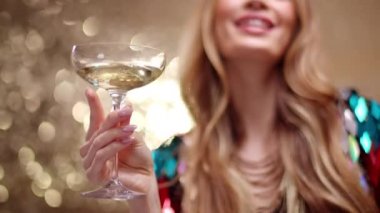 A stylish and pretty woman dancing holding a glass of champagne