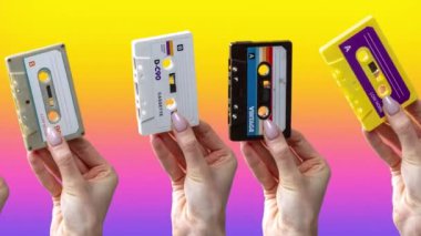 Many hands holding retro cassette tapes with abstract background