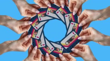 Many hands holding retro cassette tapes made into a circular pattern 
