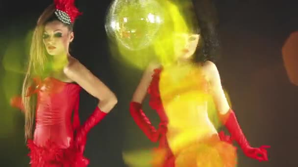 两个漂亮的滑稽可笑的女人围着一个闪闪发光的球跳舞 — 图库视频影像