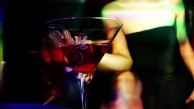 A stylish woman with a drink in a bar, lounge setting