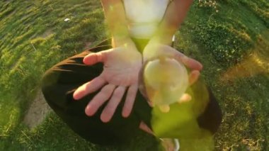 A woman plays contact juggling with a glass transparent ball