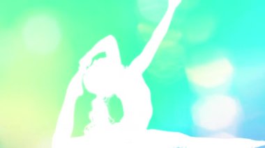 Amazing female yoga instructor moving between poses made into colourful shadows 