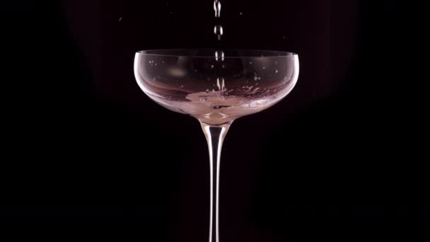 在黑色背景的杯子里倒入香槟 — 图库视频影像