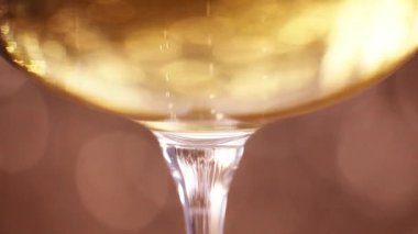 Champagne in a glass against sparkling golden background