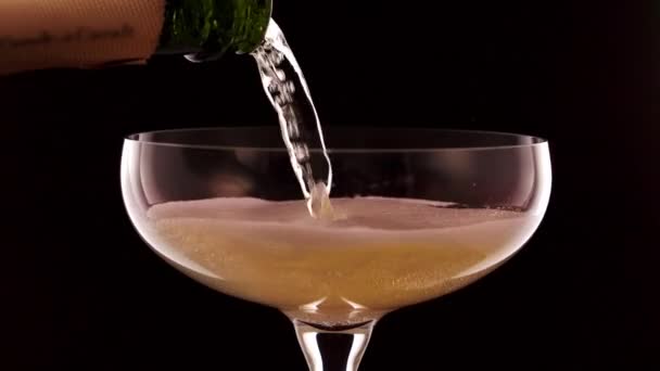 在黑色背景的杯子里倒入香槟 — 图库视频影像