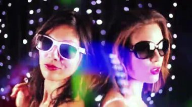 Two female friends dancing together in a night club setting