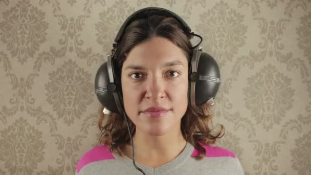Piękna Kobieta Zmieniającymi Się Słuchawkami Vintage Przeciwko Funky Tapety — Wideo stockowe