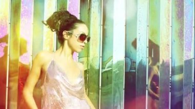 A beautiful woman dancing against urban metallic background