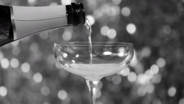 Champagne Gieten Een Glas Tegen Sprankelende Achtergrond — Stockvideo
