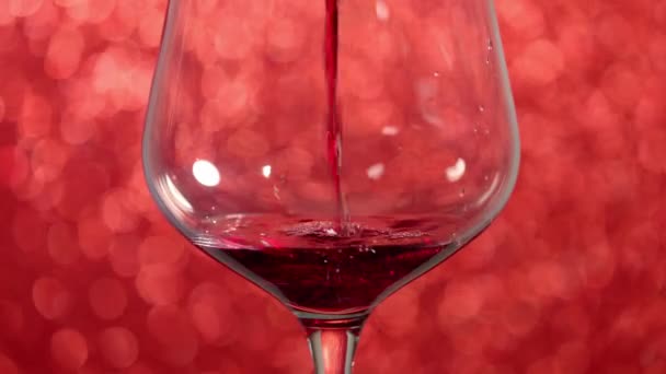 Giet Rode Wijn Een Glas Met Rode Mousserende Achtergrond — Stockvideo