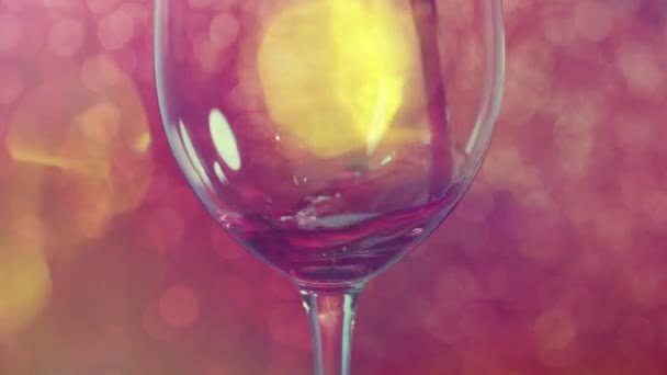 将红酒倒入有红色闪光背景的杯子中 — 图库视频影像