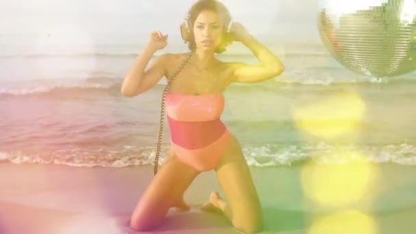 一个漂亮的女人穿着比基尼戴着镜子球在海滩上跳舞 — 图库视频影像