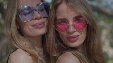 Güneş gözlüklü tek yumurta ikizi kadınlar.