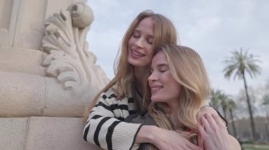 Parkta poz verip sarılan tek yumurta ikizi kadınlar.