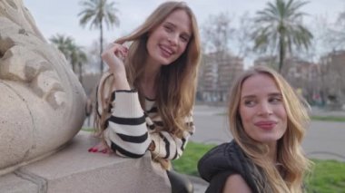 Parkta poz verip sarılan tek yumurta ikizi kadınlar.