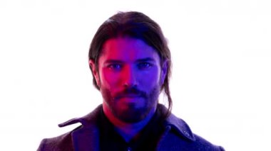 Genç bir adam kırmızı ve mavi karışık ışıklarla kameraya bakıyor. İyi bir moda ya da teknoloji konsepti