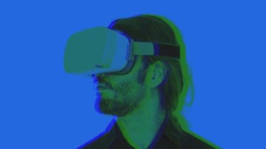 VR kulaklığı takan ve üstü kapalı bir arızayla etrafa bakan bir adam.