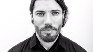 Genç bir adam kameraya siyah beyaz bakıyor ve eğiliyor. İyi bir moda ya da teknoloji konsepti