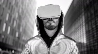 VR kulaklık takan bir adam ofis bölgesinde geziniyor.