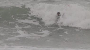 Akdeniz 'de dalga yakalayan bir erkek sörfçü.