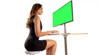 Yeşil ekranlı bilgisayarda kendi grafiklerini ekleyecek zeki bir kadın. 