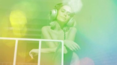 Çatı katında kulaklıklarla dans eden güzel bir kadın.