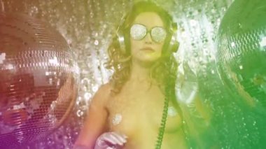 Güzel bir kadın büyük bir diskoya poz veriyor ve dans ediyor.