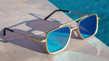 Yüzme havuzunun kenarında aynalı güneş gözlüğü.