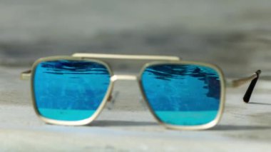 Yüzme havuzunun kenarında aynalı güneş gözlüğü.