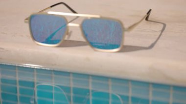 Yüzme havuzunun kenarında aynalı güneş gözlüğü.