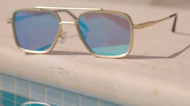 Yüzme havuzunun kenarında aynalı güneş gözlüğü.