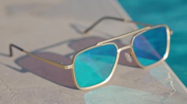 Yüzme havuzunun kenarında aynalı güneş gözlüğü.