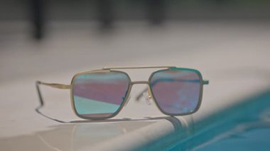 Yüzme havuzunun kenarında aynalı güneş gözlüğü.
