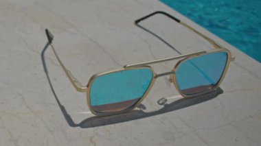 Yüzme havuzunun kenarında aynalı güneş gözlüğü.