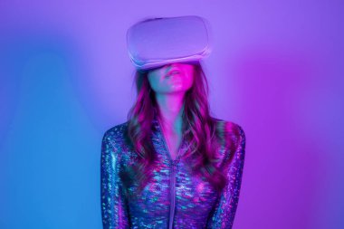 Parlak kostümlü ve VR kulaklıklı bir kadın.
