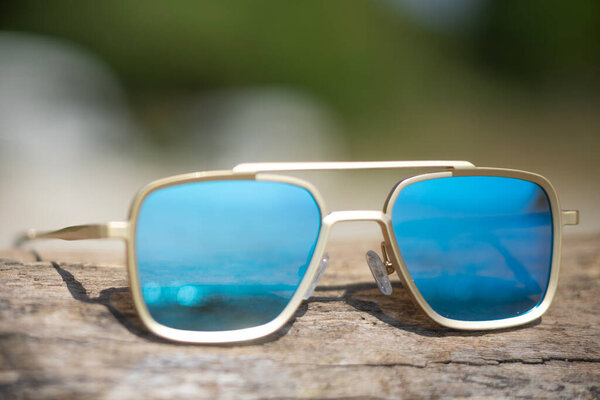 Mirrored sunglasses on a beach reflecting the sea