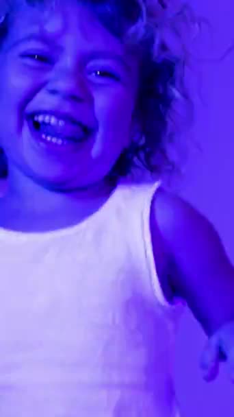 Sød Lille Pige Med Hovedtelefoner Med Farvet Disco Belysning Lodret – Stock-video