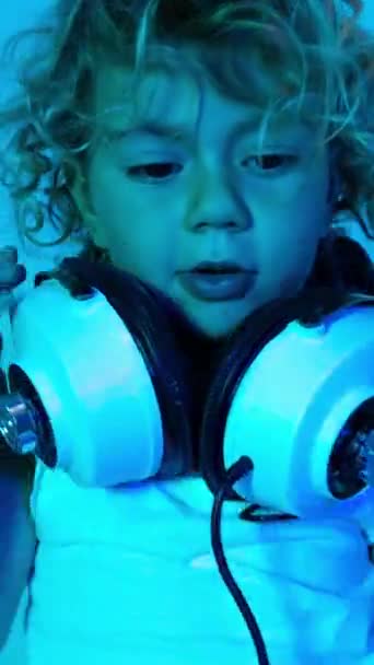 Une Jolie Petite Fille Avec Écouteurs Avec Éclairage Disco Coloré — Video