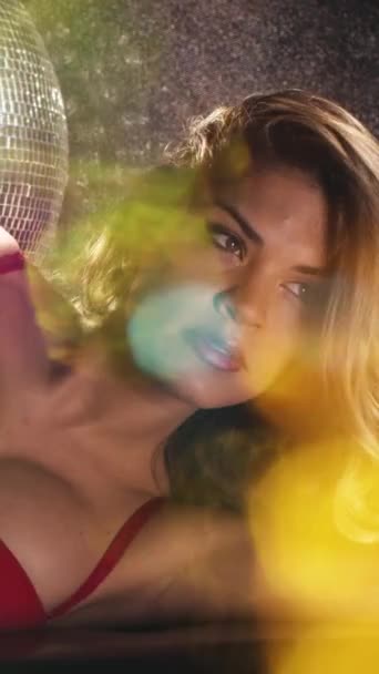 Wanita Cantik Berpose Dalam Lingerie Merah Dan Discoball Secara Vertikal — Stok Video